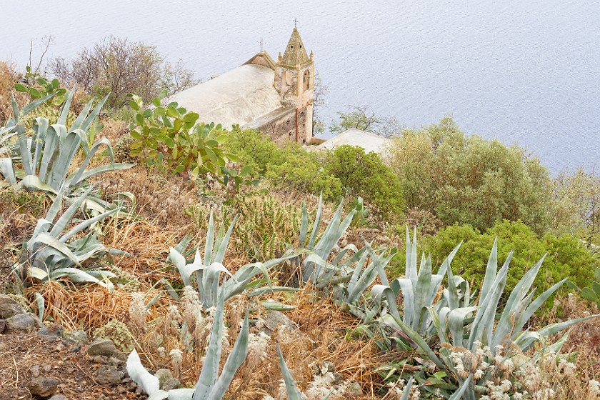 Hiking on Alicudi. Agave and Chiesa San Bartolo in the backround. Alicudi. .